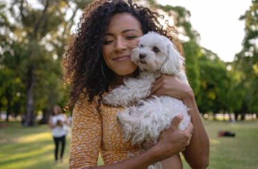 young-lady-cuddling-a-small-white-dog young-lady-cuddling-a-small-white-dog
